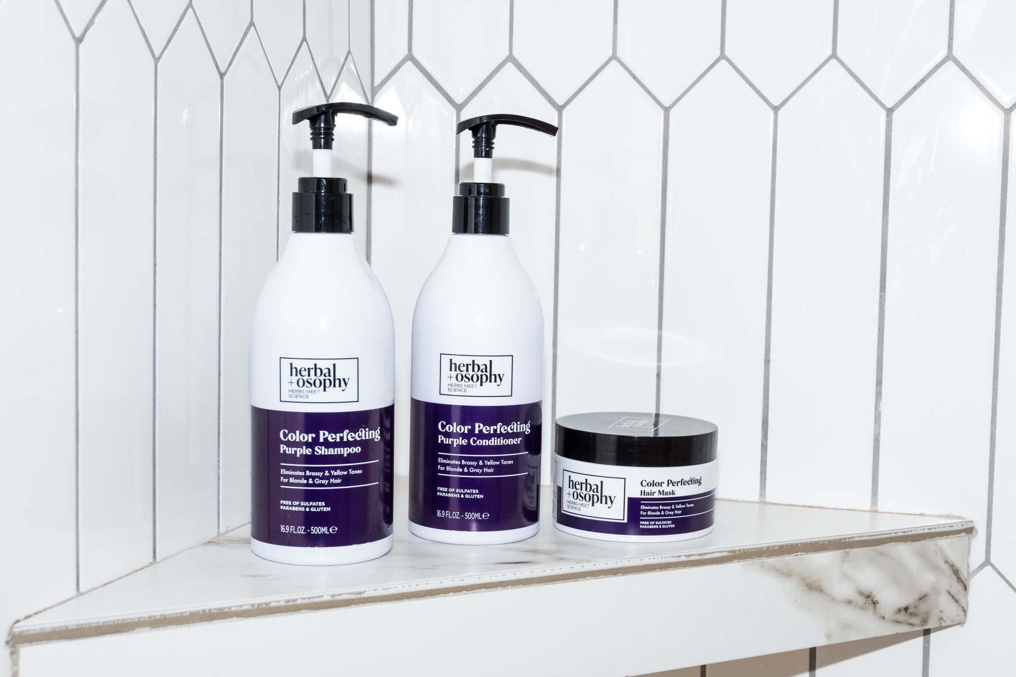Herbalosophy Color Perfecting Purple Shampoo, Conditioner and Hair Mask in shower on shelf