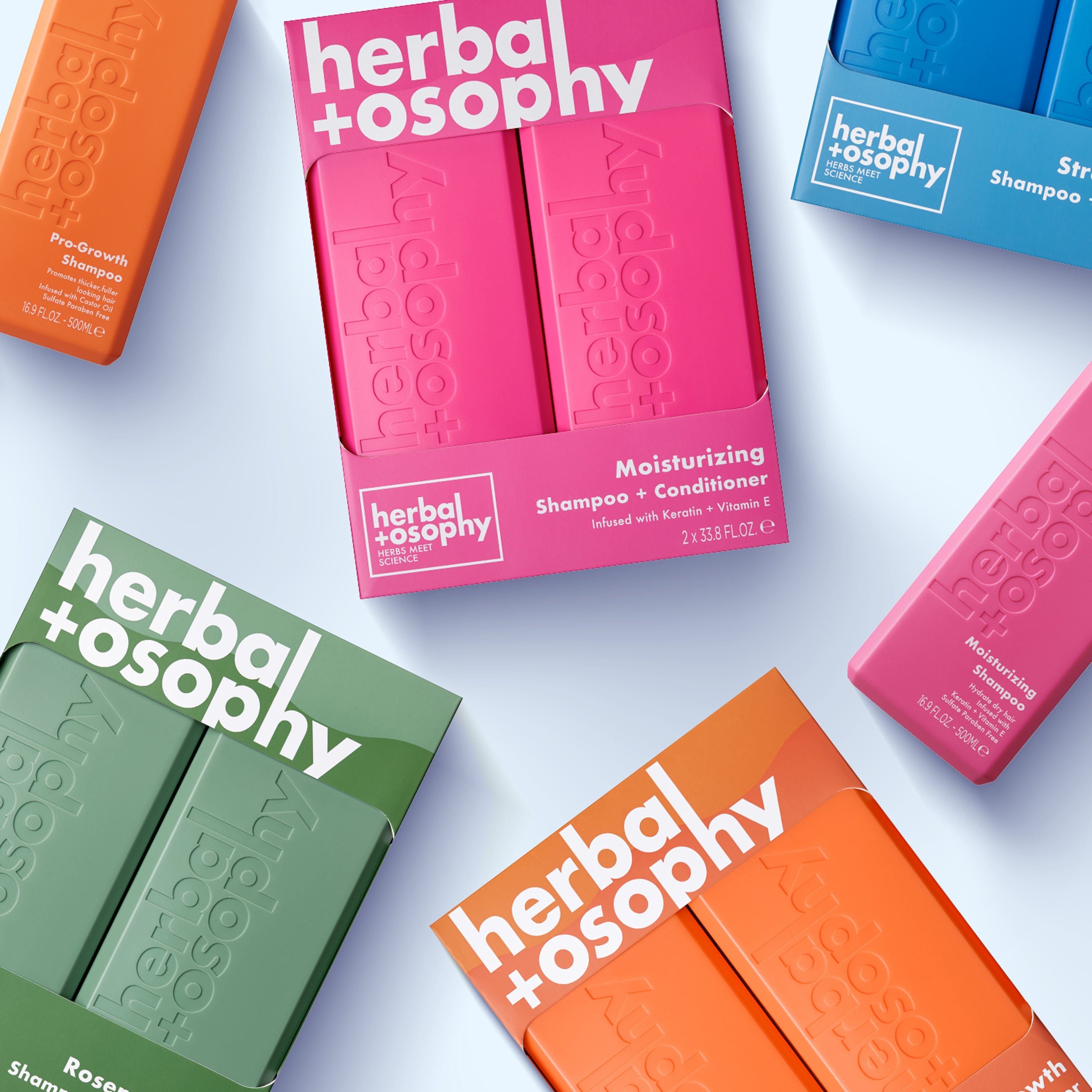 a flat lay arrangement of herbalosophy products on a light blue background.