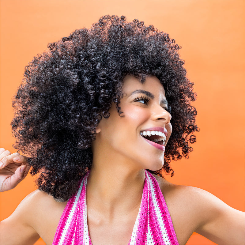a happy curly-haired model with thick, healthy hair.