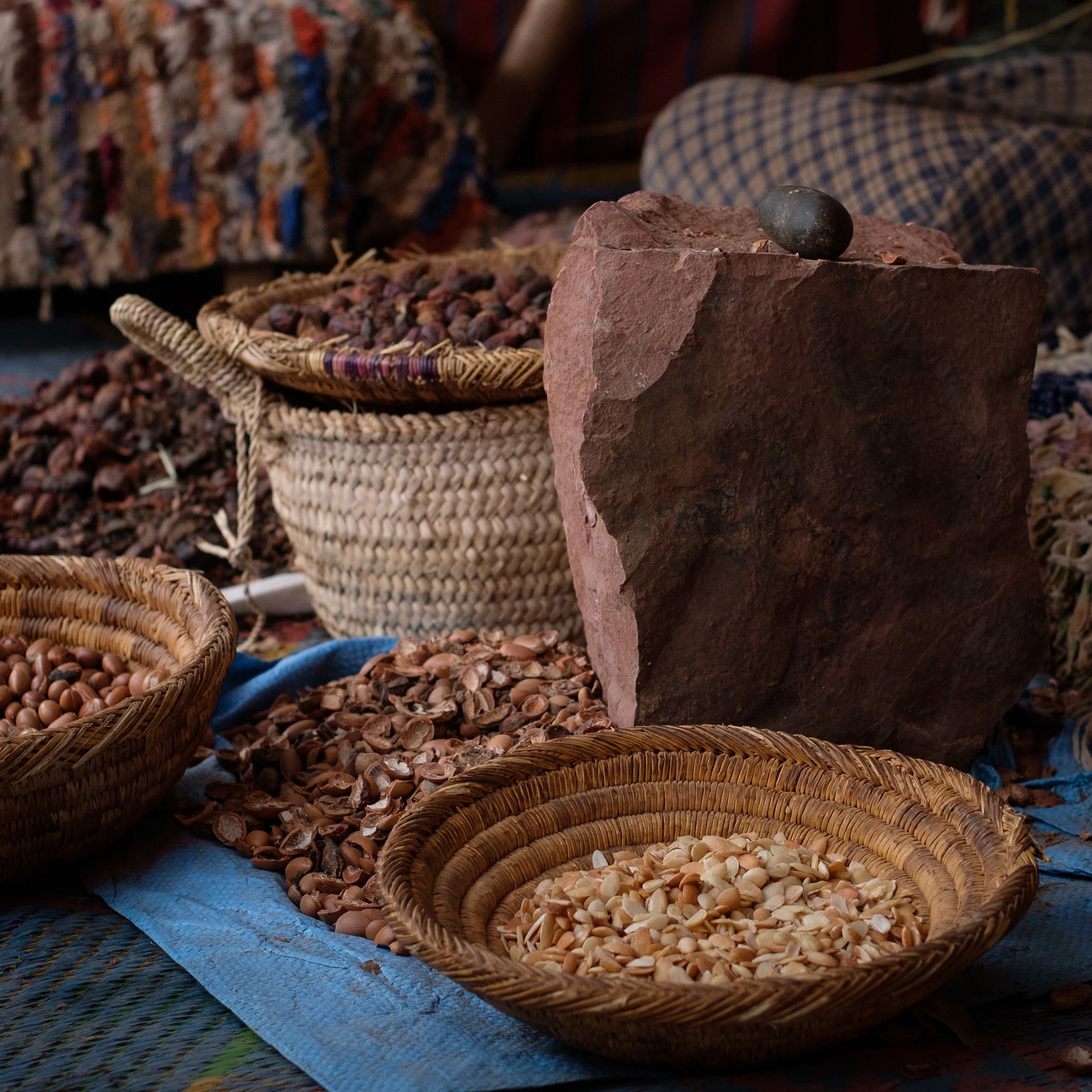 baskets full of argan seeds and stone tools used to deshell and prepare them for extracting oil