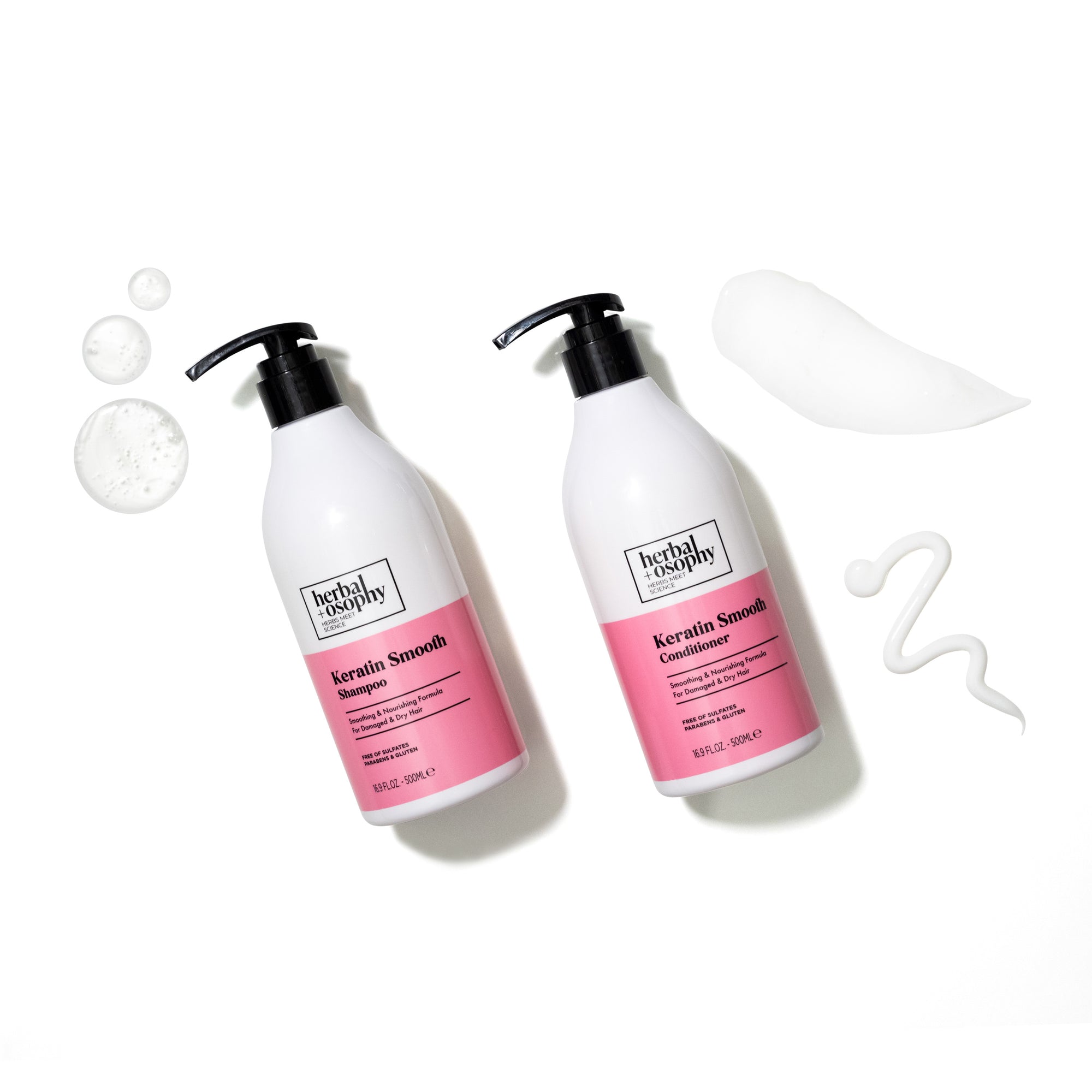 Herbalosophy Keratin Smooth Shampoo and Conditioner bottles on white background with white product drops and smears